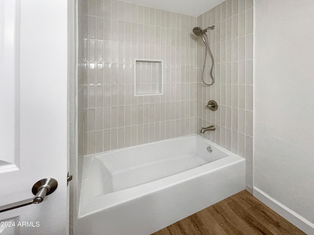 bathroom featuring tiled shower / bath combo and hardwood / wood-style flooring