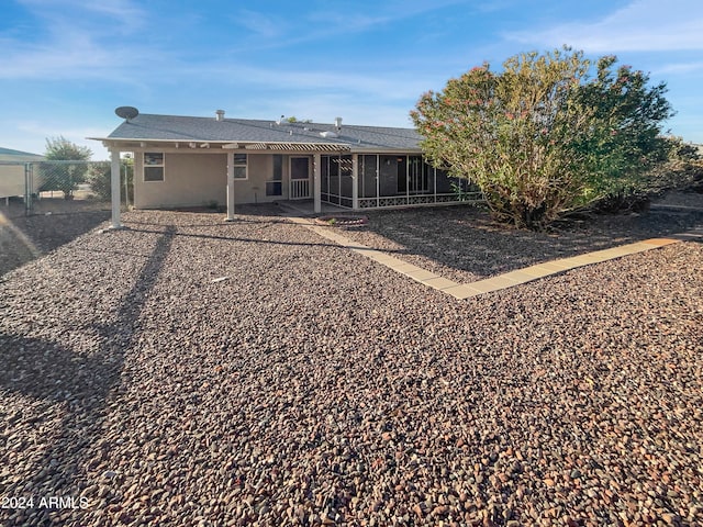 back of property featuring a sunroom and a patio area