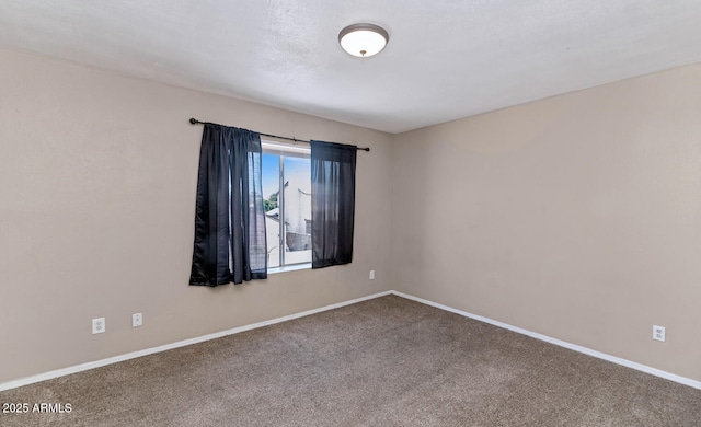 spare room featuring carpet floors and baseboards