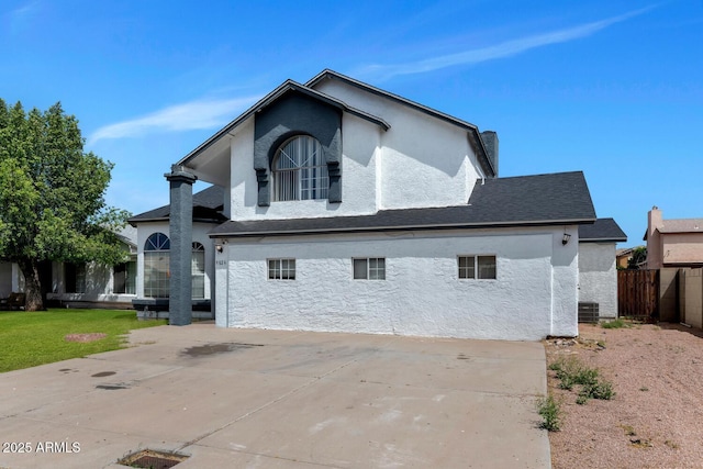 view of side of property with fence, central air condition unit, and stucco siding