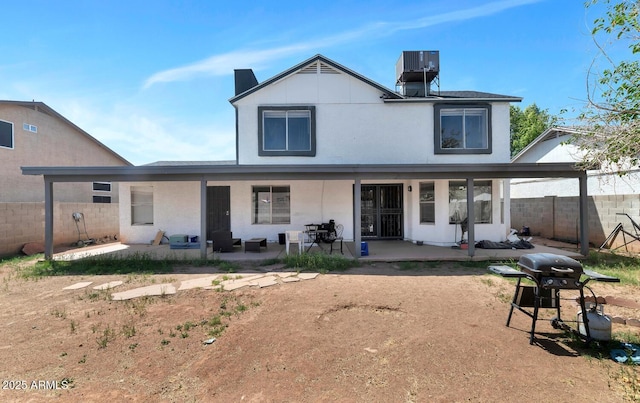 rear view of house featuring a patio, central AC, and fence