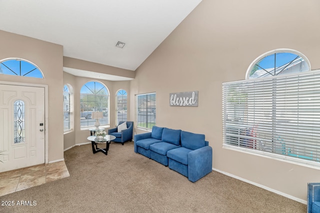 living room with baseboards, carpet, visible vents, and high vaulted ceiling