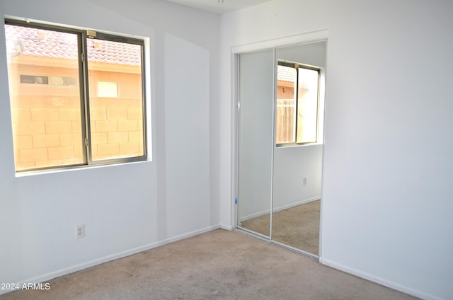 empty room with light colored carpet and a wealth of natural light