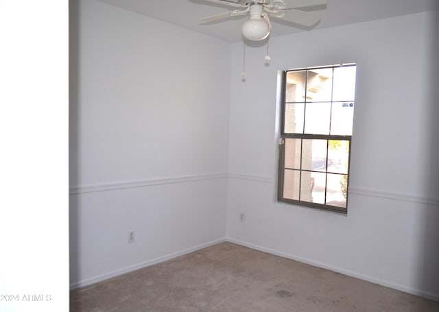 carpeted spare room featuring ceiling fan