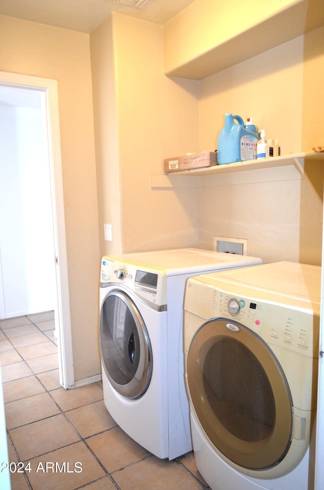 washroom featuring washing machine and clothes dryer and light tile patterned flooring