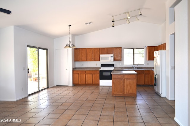 kitchen with decorative light fixtures, a center island, white appliances, and a wealth of natural light