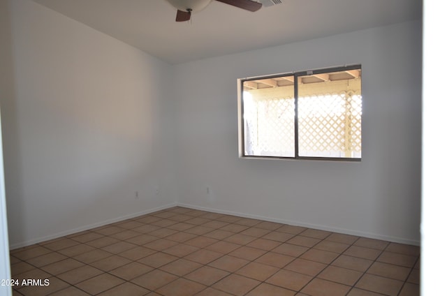 tiled spare room featuring ceiling fan