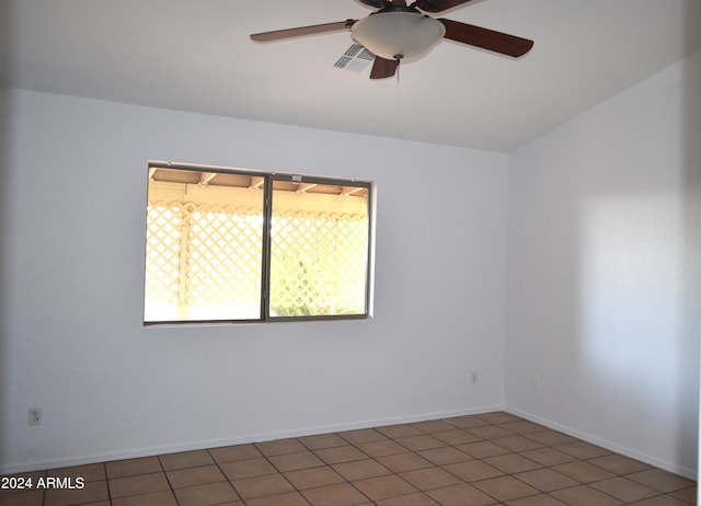 tiled spare room with ceiling fan