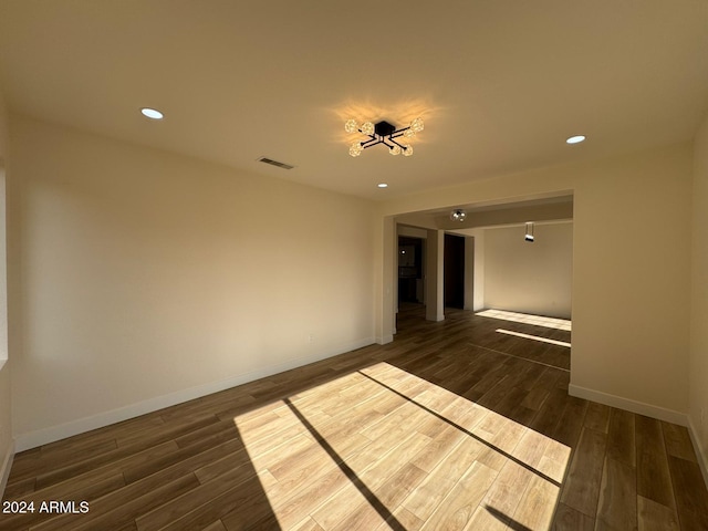 spare room featuring dark wood-style flooring, recessed lighting, visible vents, and baseboards