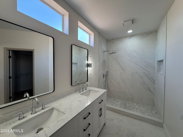 bathroom with a tile shower and vanity