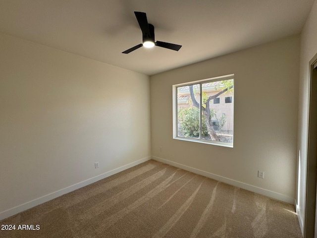 unfurnished room with carpet floors, baseboards, and a ceiling fan