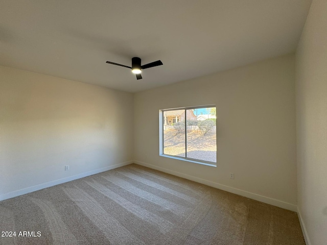 unfurnished room with ceiling fan, baseboards, and light colored carpet