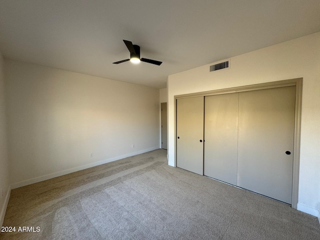 unfurnished bedroom featuring a closet, light colored carpet, visible vents, ceiling fan, and baseboards