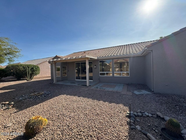 back of property featuring a patio area, a tile roof, and stucco siding