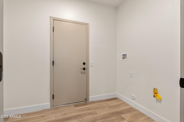 laundry room with hookup for a washing machine, laundry area, baseboards, and light wood finished floors