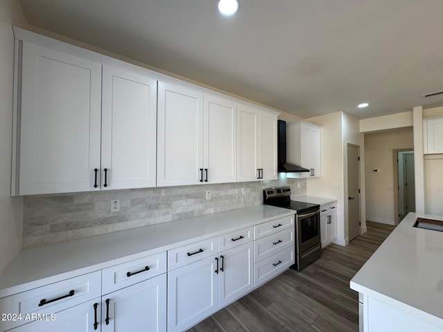 kitchen with tasteful backsplash, white cabinets, wall chimney exhaust hood, and stainless steel range with electric stovetop