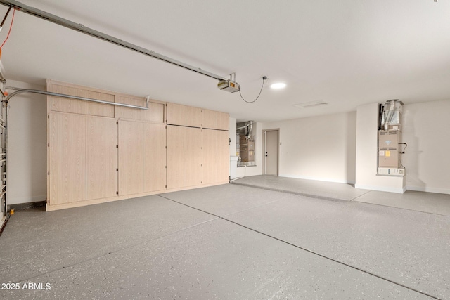 garage featuring heating unit and a garage door opener