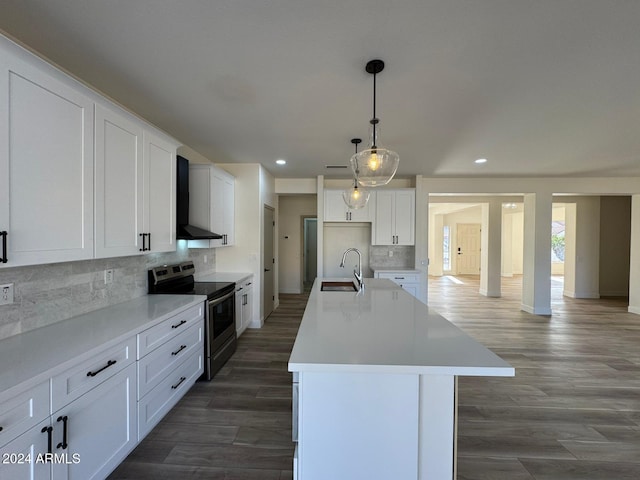 kitchen with backsplash, sink, wall chimney range hood, a center island with sink, and stainless steel electric range oven