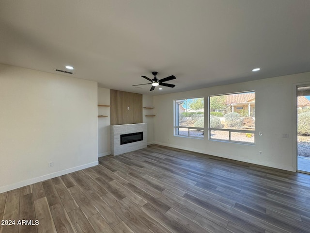 unfurnished living room featuring a fireplace, hardwood / wood-style flooring, and ceiling fan