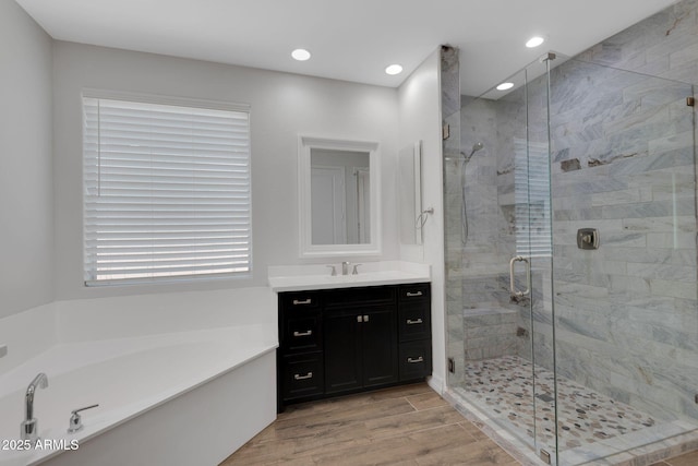 4853 N 183rd Ln, Goodyear, AZ 85395 - bathroom featuring a garden tub, vanity, wood finished floors, a shower stall, and recessed lighting
