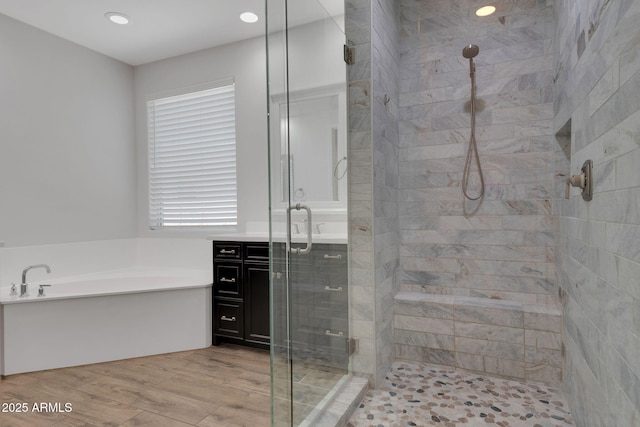 4853 N 183rd Ln, Goodyear, AZ 85395 - bathroom with a stall shower, a bath, wood finished floors, and recessed lighting