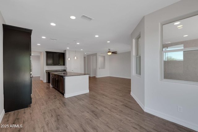 4853 N 183rd Ln, Goodyear, AZ 85395 - kitchen with open floor plan, wood finished floors, a ceiling fan, recessed lighting, and a center island with sink