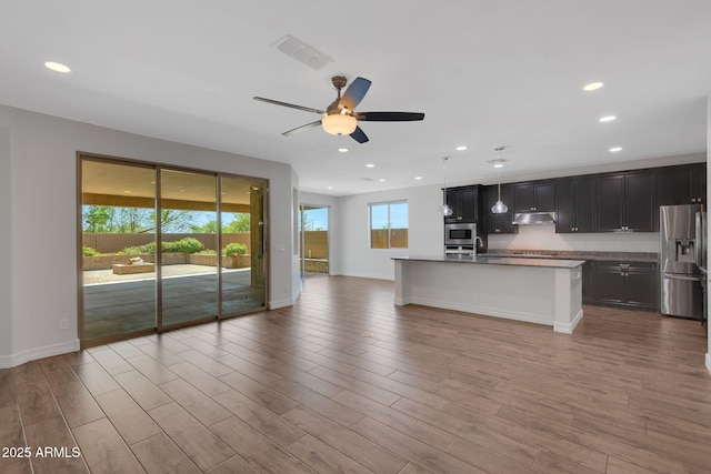 4853 N 183rd Ln, Goodyear, AZ 85395 - kitchen featuring appliances with stainless steel finishes, under cabinet range hood, open floor plan, a ceiling fan, and recessed lighting