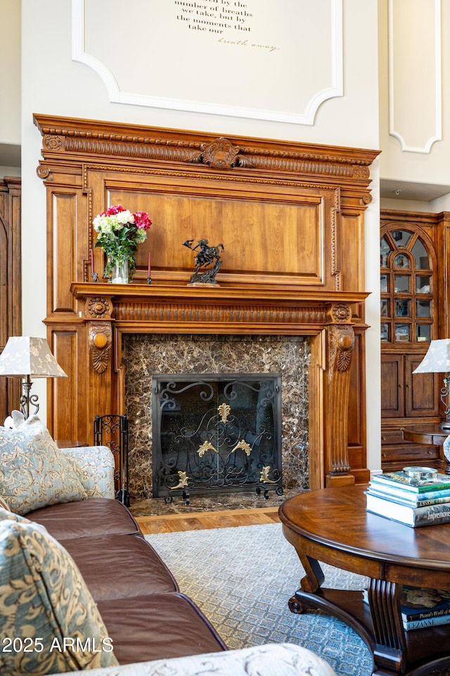 living room featuring wood finished floors and a high end fireplace
