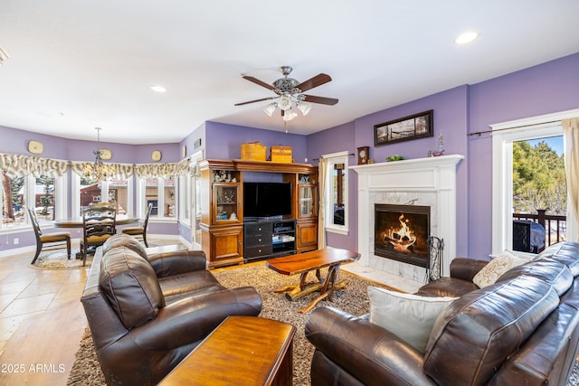 living room with baseboards, plenty of natural light, ceiling fan, and a high end fireplace