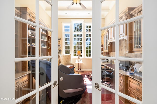 interior space featuring baseboards, ornamental molding, and a ceiling fan