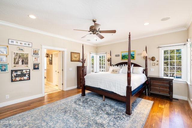 bedroom featuring baseboards, multiple windows, wood finished floors, and crown molding