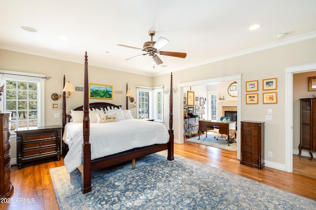 bedroom with baseboards, wood finished floors, and crown molding