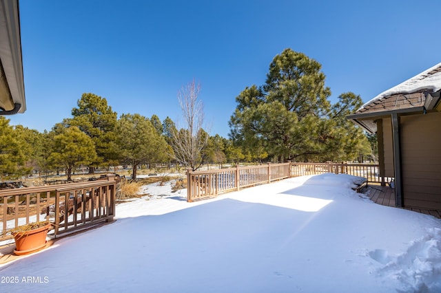 snowy yard featuring a deck