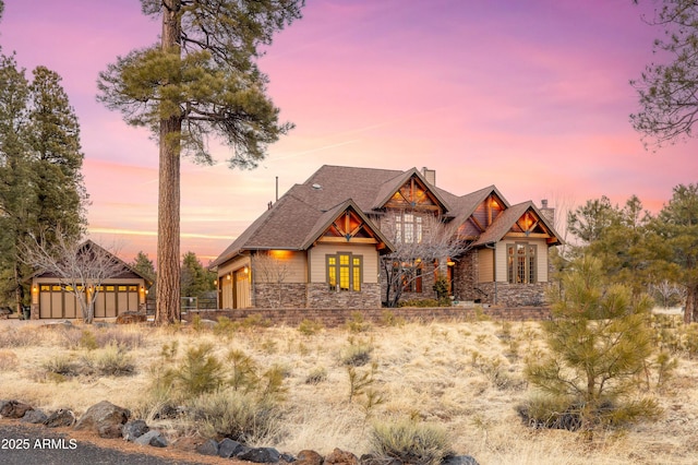craftsman inspired home featuring stone siding, roof with shingles, and a chimney
