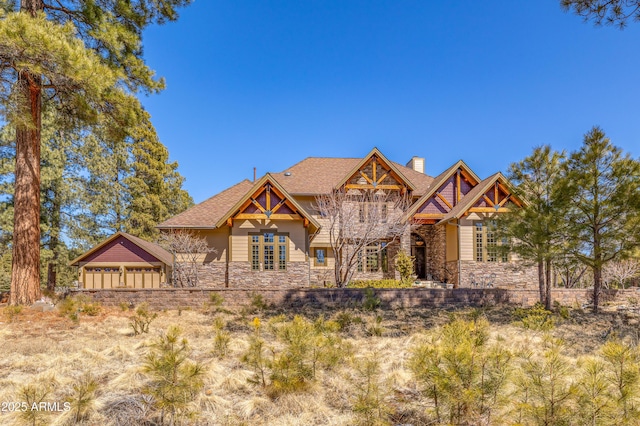 craftsman-style home featuring stone siding and a chimney