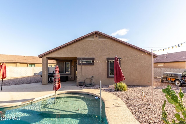 back of house featuring a fenced in pool and a patio