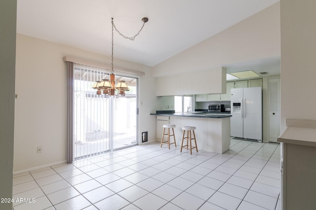 kitchen featuring light tile patterned flooring, kitchen peninsula, white fridge with ice dispenser, a chandelier, and white cabinets