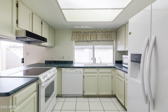 kitchen with light tile patterned floors, white appliances, cream cabinetry, and sink