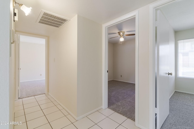 corridor featuring light colored carpet