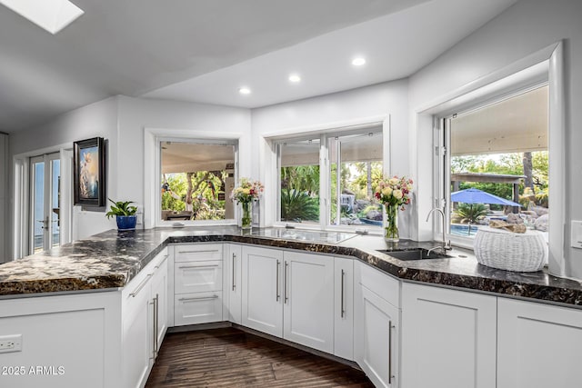kitchen with a sink, black electric stovetop, plenty of natural light, dark wood-style floors, and recessed lighting