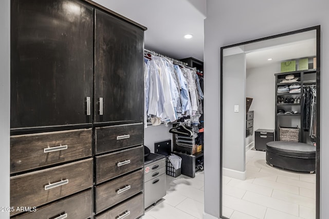 walk in closet with light tile patterned floors