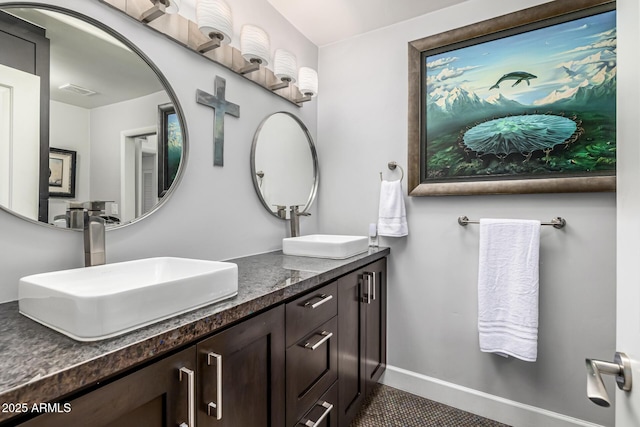 bathroom with double vanity and tile patterned flooring