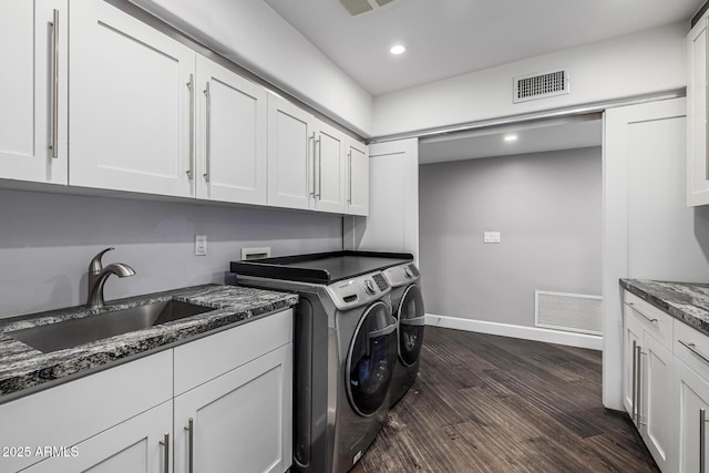 laundry room with cabinet space, washing machine and clothes dryer, dark wood finished floors, baseboards, and recessed lighting