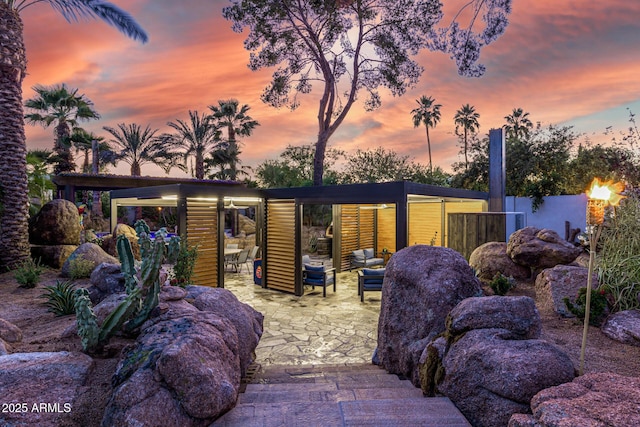 outdoor structure at dusk with an outdoor hangout area and fence