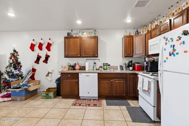 kitchen featuring white appliances, sink, and light tile patterned floors