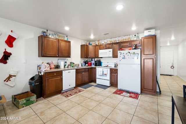 kitchen with light tile patterned flooring, white appliances, and sink