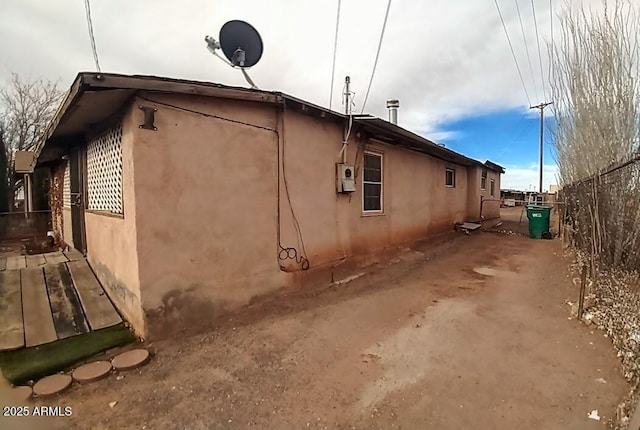 view of property exterior with fence and stucco siding