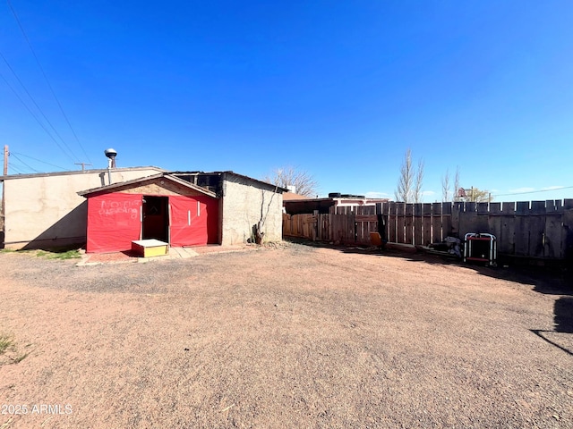 view of yard featuring fence, a storage unit, and an outbuilding