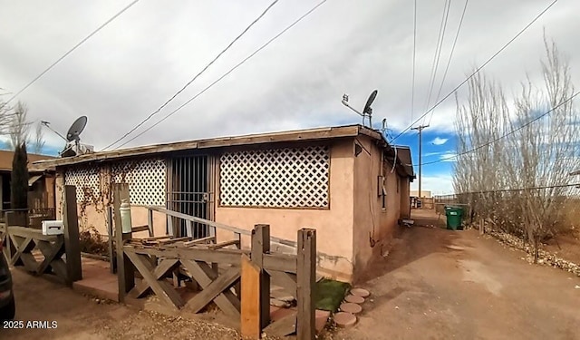 view of home's exterior with fence and stucco siding