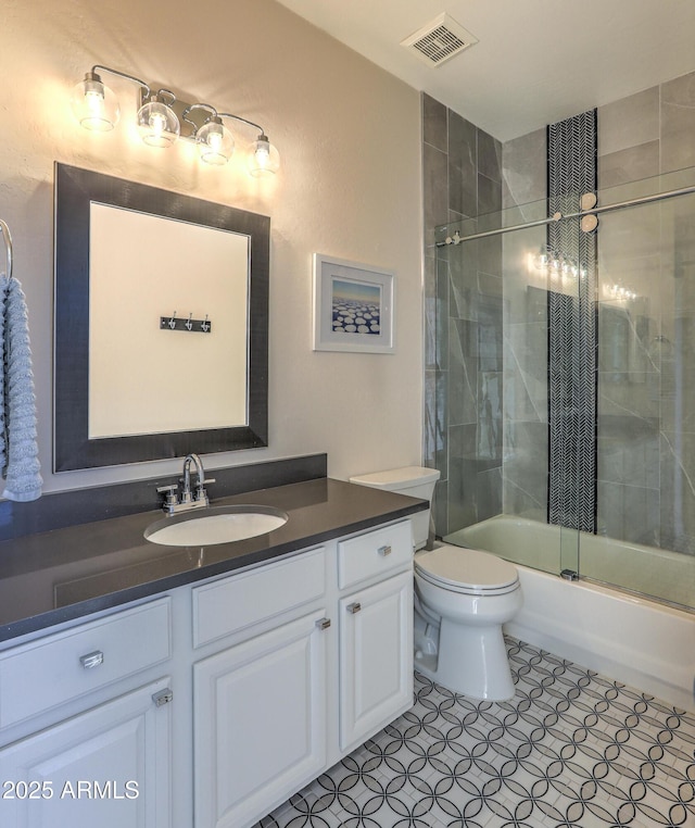 full bathroom with vanity, tile patterned floors, toilet, and combined bath / shower with glass door